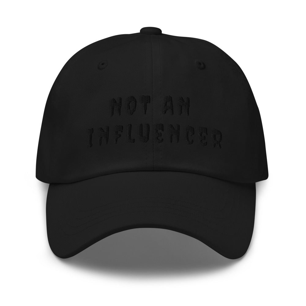black ball cap with black lettering that says not an influencer for a monochrome look black on black